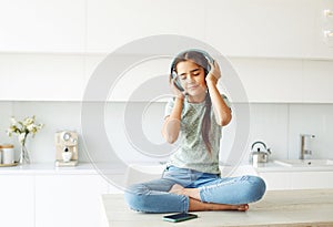 girl with pigtails with headphones listening to music at home