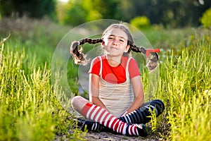 Girl with pigtails imagines the summer on the nature