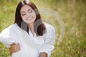 The girl with a pillow on the fresh spring grass.