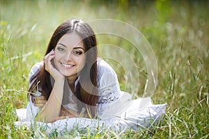 The girl with a pillow on the fresh spring grass.