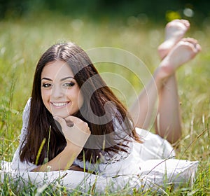 The girl with a pillow on the fresh spring grass.