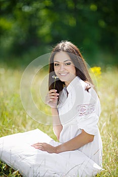 The girl with a pillow on the fresh spring grass.