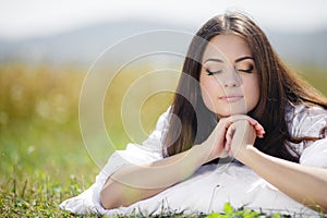 The girl with a pillow on the fresh spring grass.