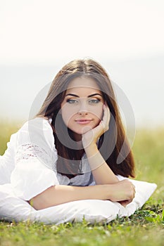 The girl with a pillow on the fresh spring grass.