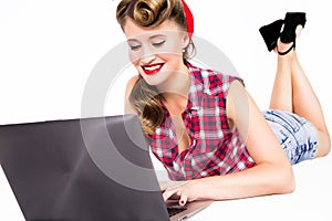 Girl in pin-up style with laptop on the floor