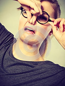 Girl pinches her nose because of stench stink.