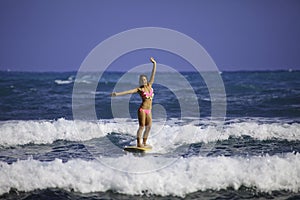 Girl in pink bikini surfing