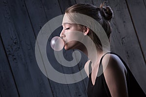 Girl with pink bubble of chewing gum