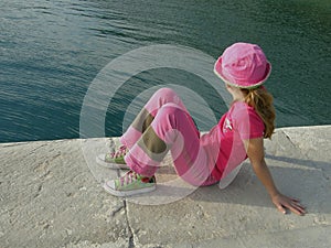 Girl in pink cap and blue sea