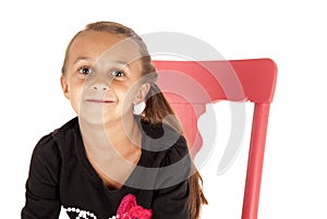 Girl in pink chair close up with a cheesy grin