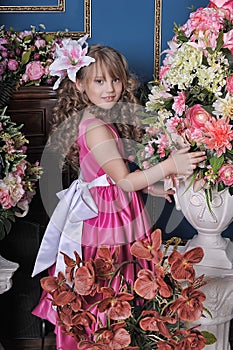 Girl in a pink dress among the flowers