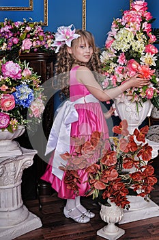 Girl in a pink dress among the flowers