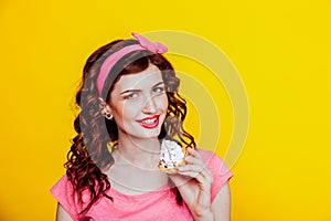 Girl in pink dress pinup-style eats cake with cream