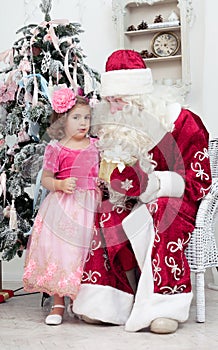 Girl in a pink dress talks to Saint Nicolas