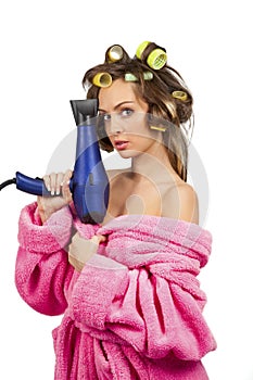 Girl in pink dressing gown with blue hairdryer