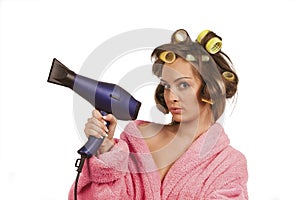 Girl in pink dressing gown with blue hairdryer