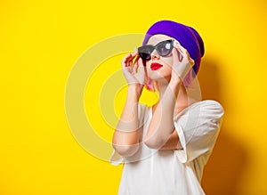 Girl with pink hair in purple hat and sunglasses