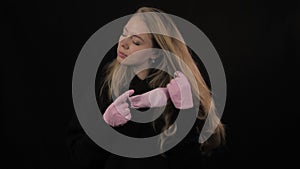 Girl in a pink medical mask takes off the mask and coughs. Isolated on black background. Health care and medical concept