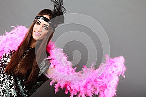 Girl pink plume and black feather on head. Carnival.