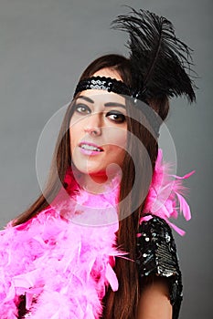 Girl pink plume and black feather on head. Carnival.