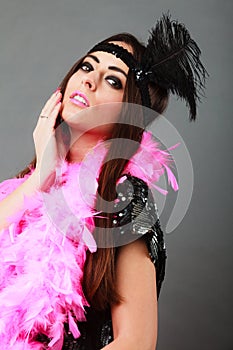 Girl pink plume and black feather on head. Carnival.