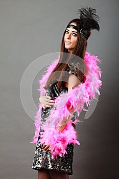 Girl pink plume and black feather on head. Carnival.