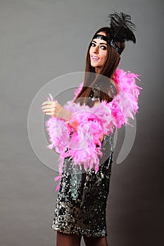 Girl pink plume and black feather on head. Carnival.