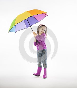 Girl in pink rain boots with rainbow umbrella