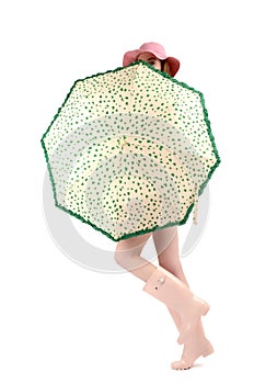 Girl in pink rubber boots with hat and cute green umbrella with hearts.