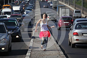Girl in pink skirt runs on highway middle photo