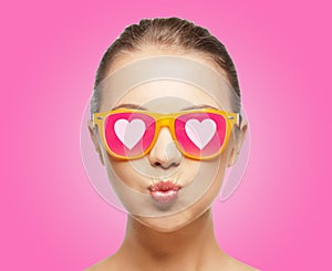Girl in pink sunglasses blowing kiss