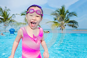 Girl in pink swim suit smiling in swimming pool