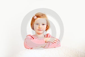 Girl in a pink T-shirt and bow in her hair on the white background