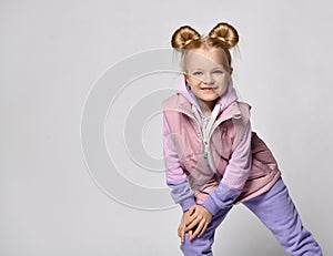 Girl in pink violet color sportive outwear posing for camera studio shot