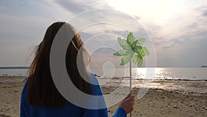 Girl with pinwheel in hand on the beach