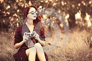 Girl in plaid dress retro camera and sunglasses