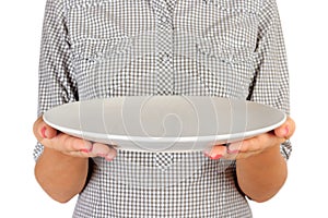 Girl in the plaid shirt is holding an empty round matte plate in front of her. woman hand hold empty dish for you desing. perspect