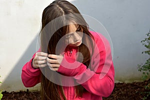 Girl plaiting her hair, tries to make pigtails