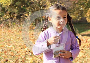 Girl with plaits eating seeds photo