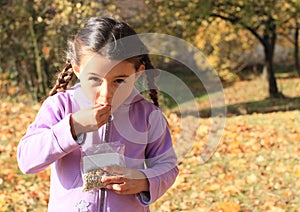 Girl with plaits eating seeds