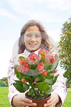 Girl with plant pot in park.