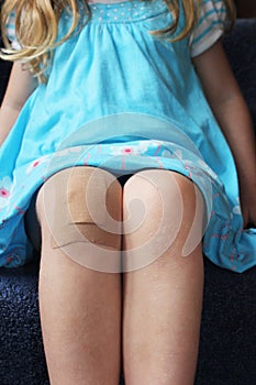 Girl with plaster on her knee photo