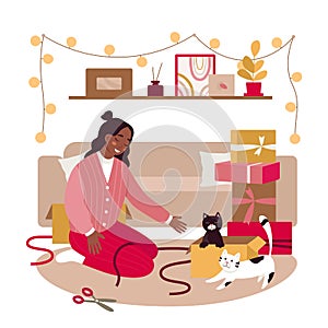 Girl play with cats in home living room with Christmas gifts, festive garland and couch