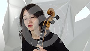 Girl play cello two girls playing the violins in the white studio