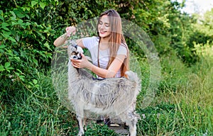 Girl play cute goat. Veterinarian occupation. Eco farm. Love and care. Feeding animal. Animals law. Woman and small goat