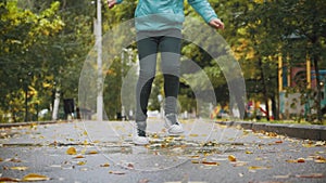 Girl play and jump in puddle in park after autumn rain. Fall rainy weather outdoors activity for young child. Kid