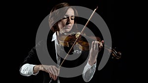 Girl in play the violins in a room. Black background