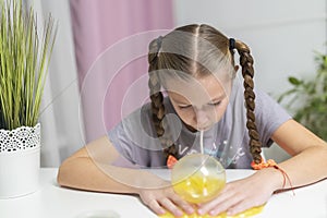 Girl play with yellow slime inflates bubble fun at home