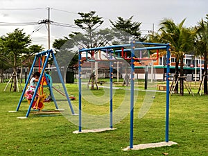 A girl play yellow swing shape duck Set in a playground
