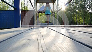 A girl on the playground walking on a straight shaky pathstraight